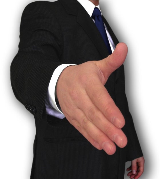 Man in a suit, holding out hand to shake