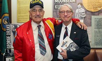 Two men in front of a Legacy Washington display