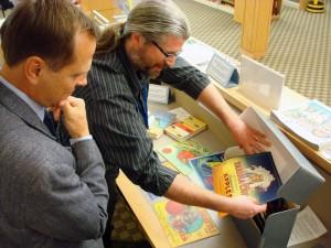 WSL Special Collections Librarian Sean Lanksbury, shows a new collection of Washington fruit box labels to Assistant Secretary of State, Ken Raske.